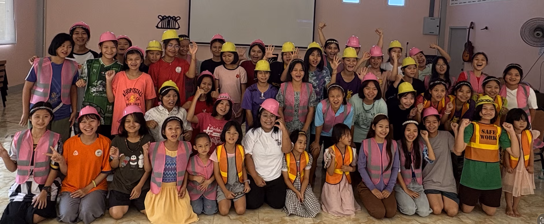 The girls and team in hard hats and Arise and Build t-shirts